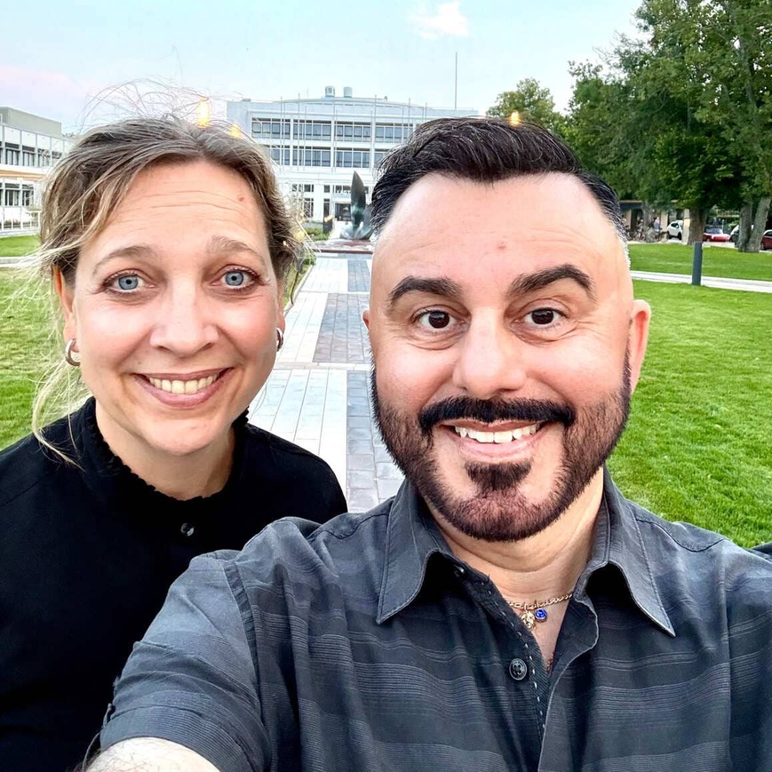 Direktören Tasso Stafilidis tar en selfie tillsammans med en kvinna utomhus i en parkmiljö.